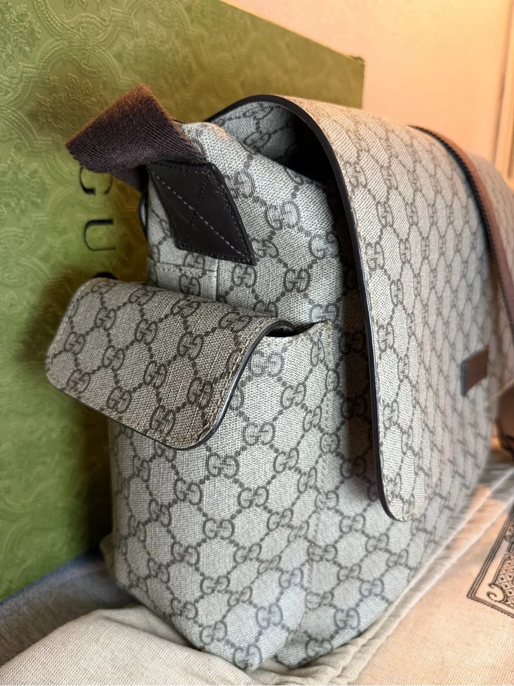 GG Supreme canvas diaper bag, designed with multiple pockets and fold-out pad